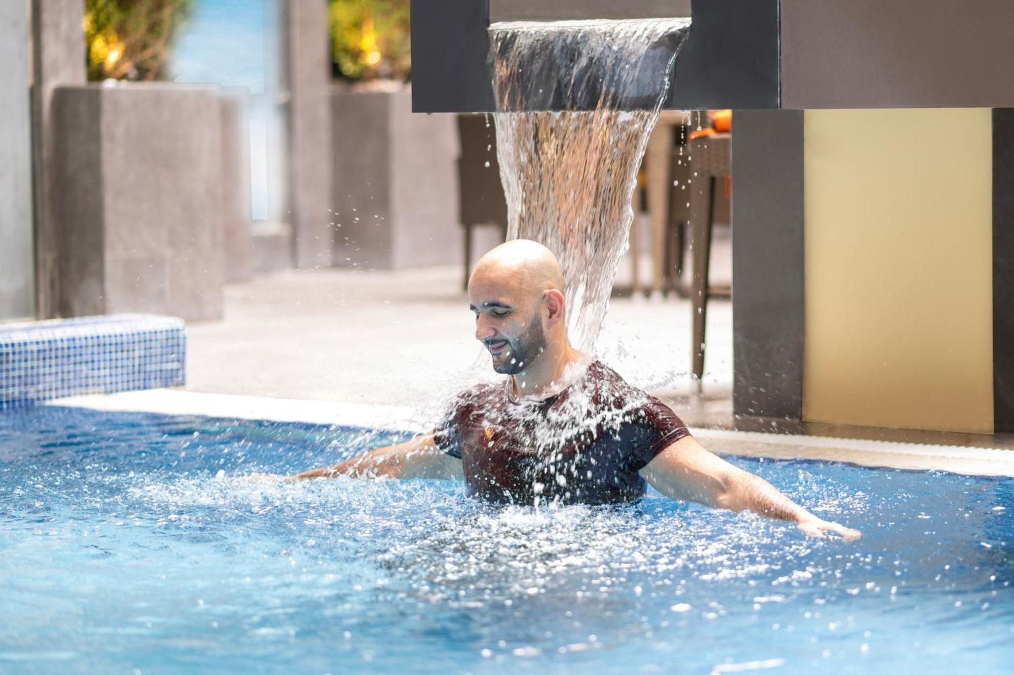 Delta Hotels By Marriott City Center Dauhá Exteriér fotografie A man swimming in a pool