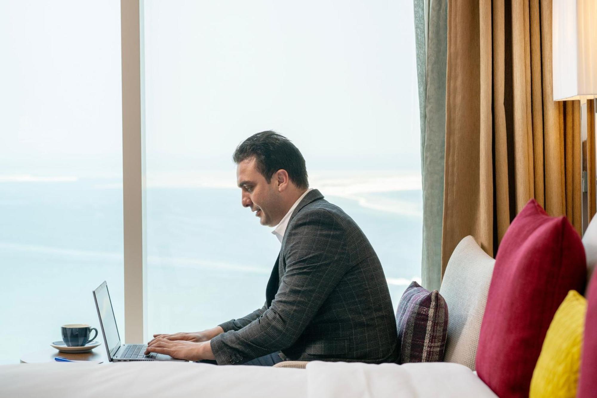 Delta Hotels By Marriott City Center Dauhá Exteriér fotografie A businessman working on a laptop