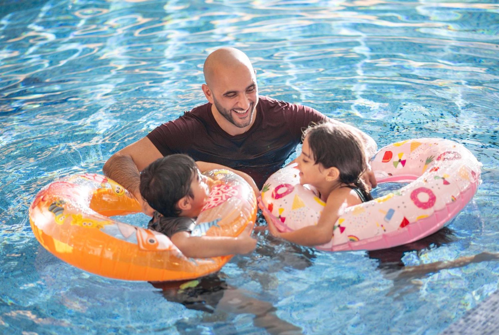 Delta Hotels By Marriott City Center Dauhá Exteriér fotografie A father and two children in a swimming pool